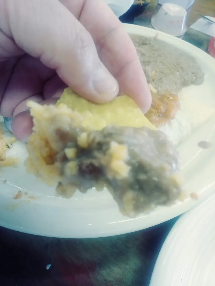 Last Bite of a Taco Dipped in Refried Beans